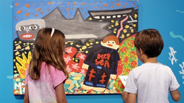 A boy and girl are looking at an artwork from All the best, from Martin Edge.