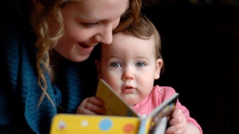 A mother reading to a baby