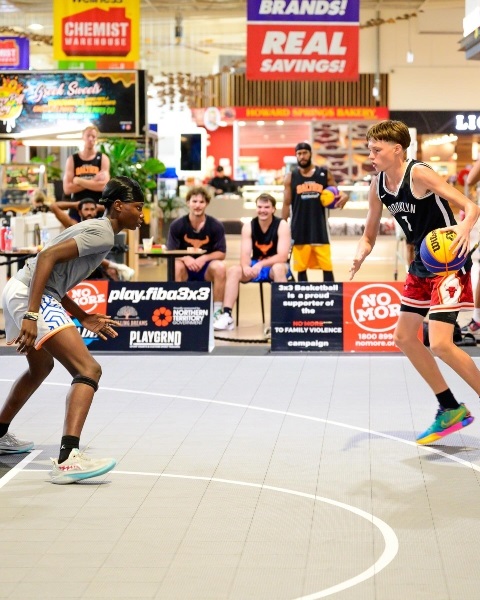 Two basketball players on a court playing 1 on 1