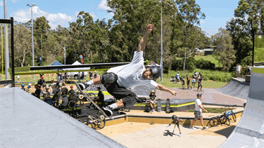 A man wearing a helmet is performing a skateboard trick.