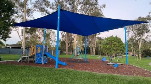 Blue shade-covered playground at Wally Strong Park