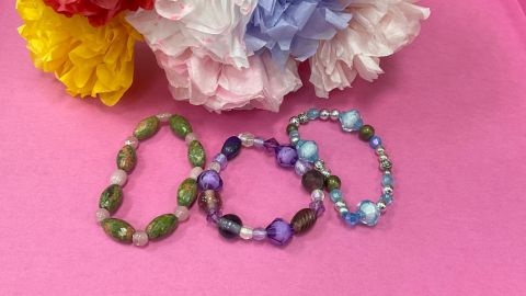 Three beaded bracelets on a pink background