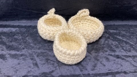 Three cream-coloured crochet baskets