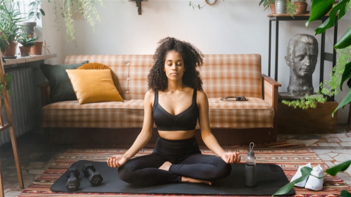 A women meditating on the floor of her home