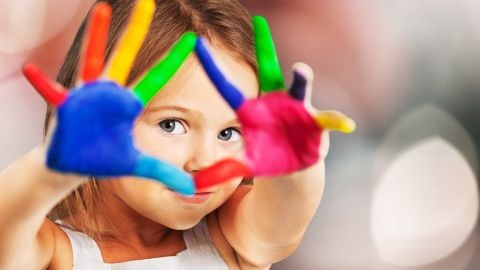 Young girl with coloured paint on her hands