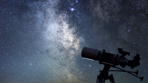 A sky full of stars with a telescope in the foreground