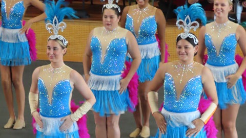 A group of children in sparkly blue outfits dancing