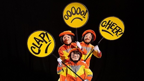 Three female characters dressed as lollipop ladies carrying reactive signs