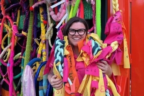 Shan Michaels surrounded by colourful strips of fabric