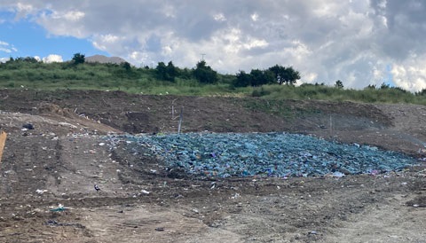 Blue ACM covering the ground of a landfill site.