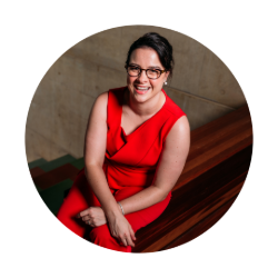 Bee Brooke sitting on wooden stairs smiling