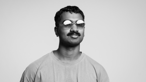 Black and white image of musician Ruwan Joseph wearing glasses and a mustache