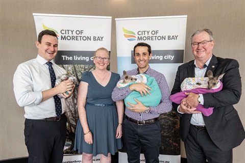 Mayor and attendees hold local wildlife in fromt of City of Moreton Bay Banners