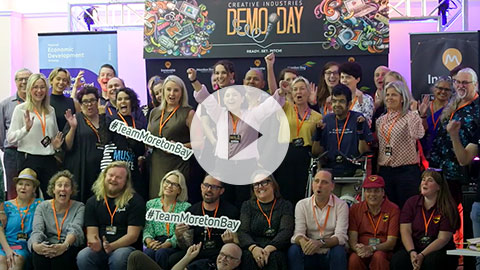 Demo Day group photo behind play video button